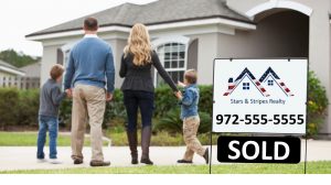 family standing in front of home with sold sign